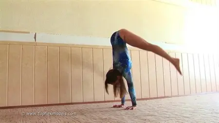 Flexible Schulmädchen ist mit Gymnastik vor der Kamera beschäftigt