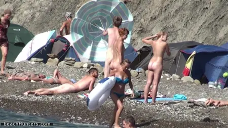 Nackte Menschen werden heimlich am Strand genommen