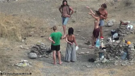 Nudisten ziehen sich an einem verlassenen Strand aus