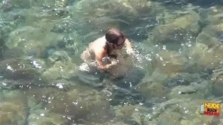 Der Typ spioniert seine Freundin aus, die nackt im Meer badet