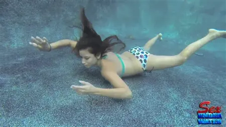 Ein schlankes Mädchen versucht, einen Gummi -Schwanz unter Wasser zu saugen
